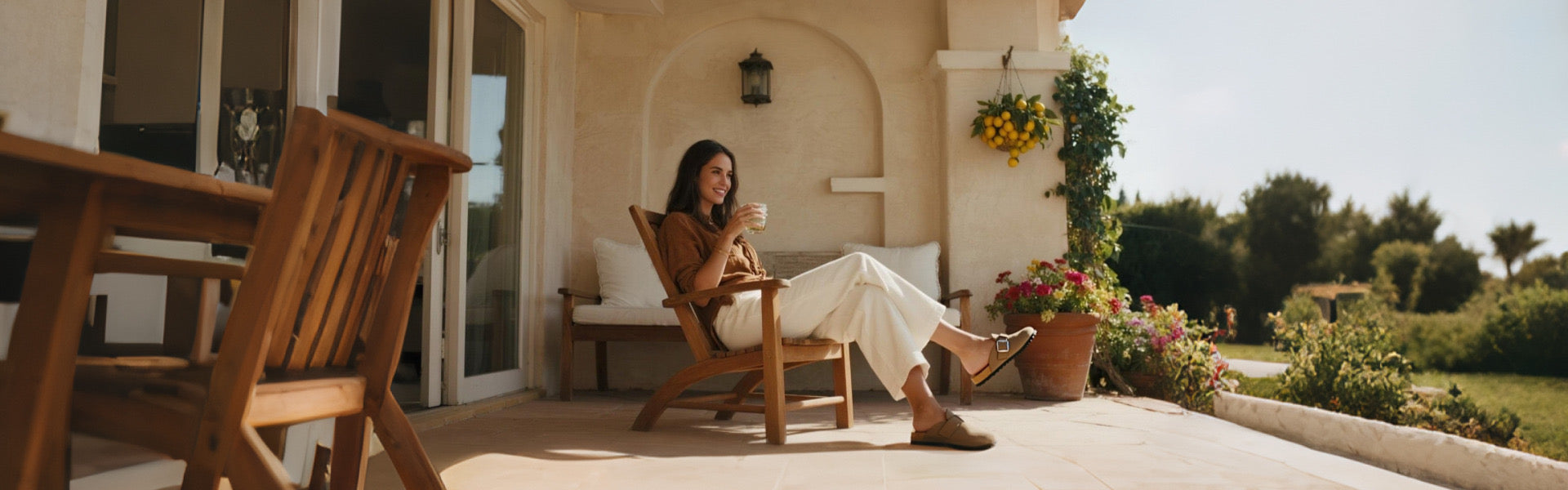 A woman relaxing on a sunny patio wearing stylish brown slip-on shoes with buckle detail
