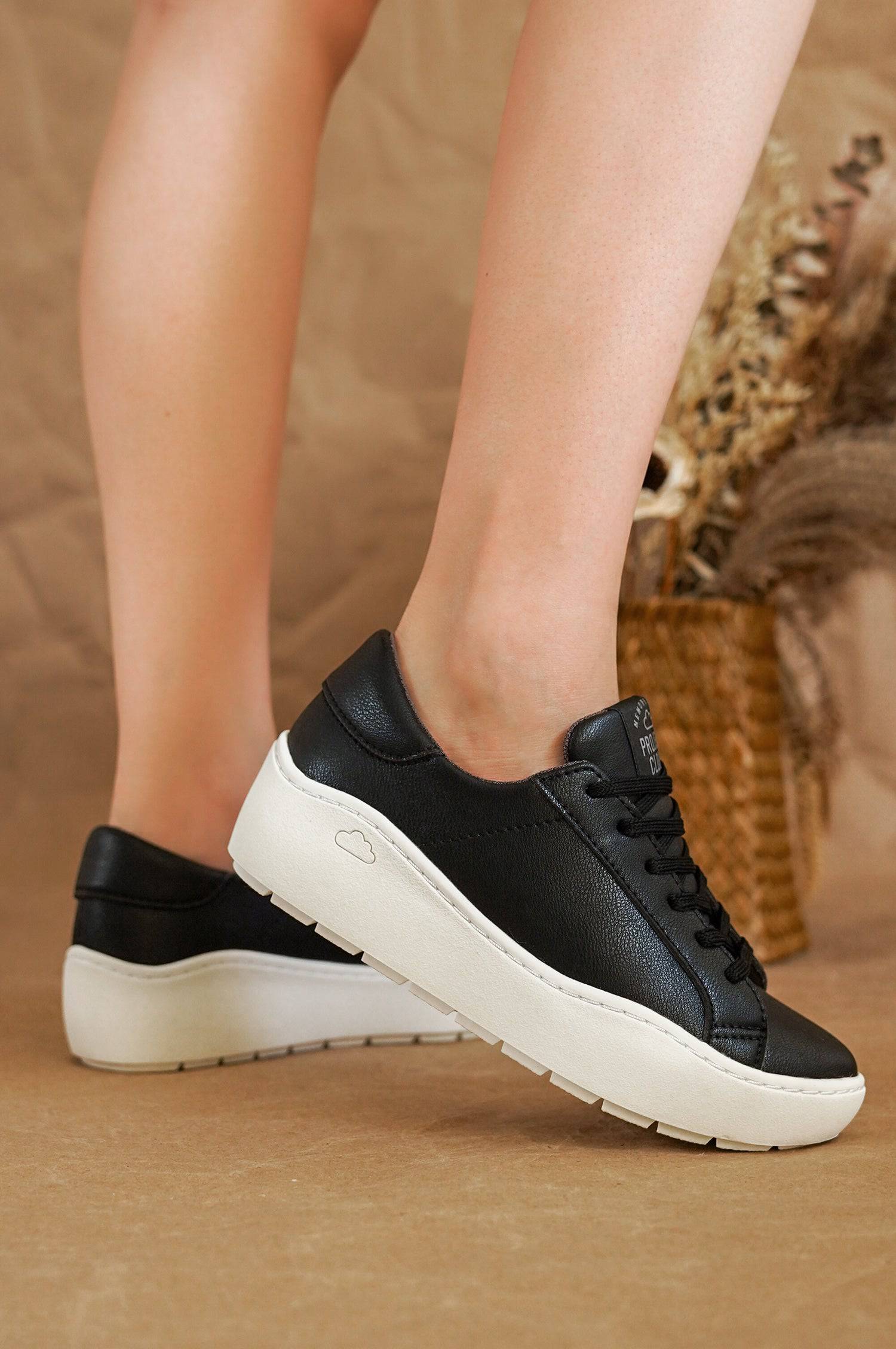 Black "Bossy" platform sneakers by Project Cloud. White sole, lace-up design. Women's stylish, comfortable footwear.