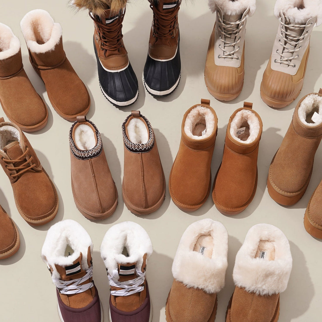 arious winter boots arranged in rows on a light background