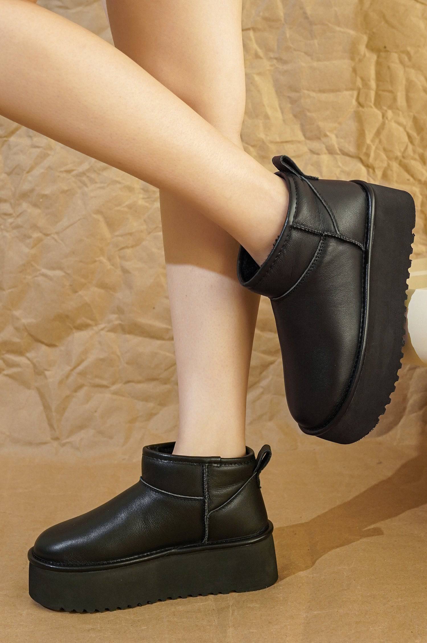 Black leather Huggy ankle boots for women with platform sole and faux fur lining. Lightweight winter boots.