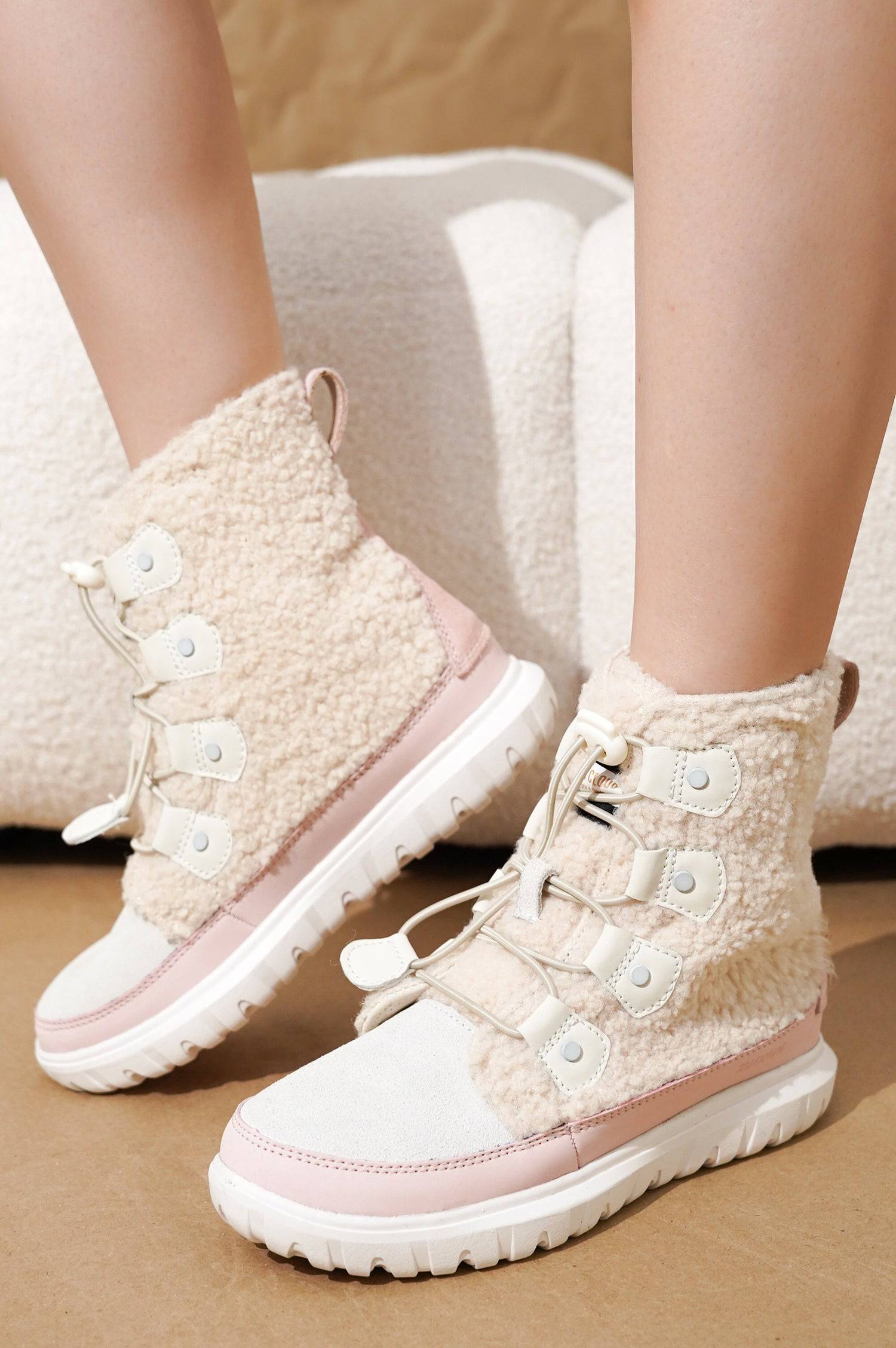 Project Cloud Leonora snow boots in light pink and cream, featuring sherpa-like material, lace-up design and non-slip sole.