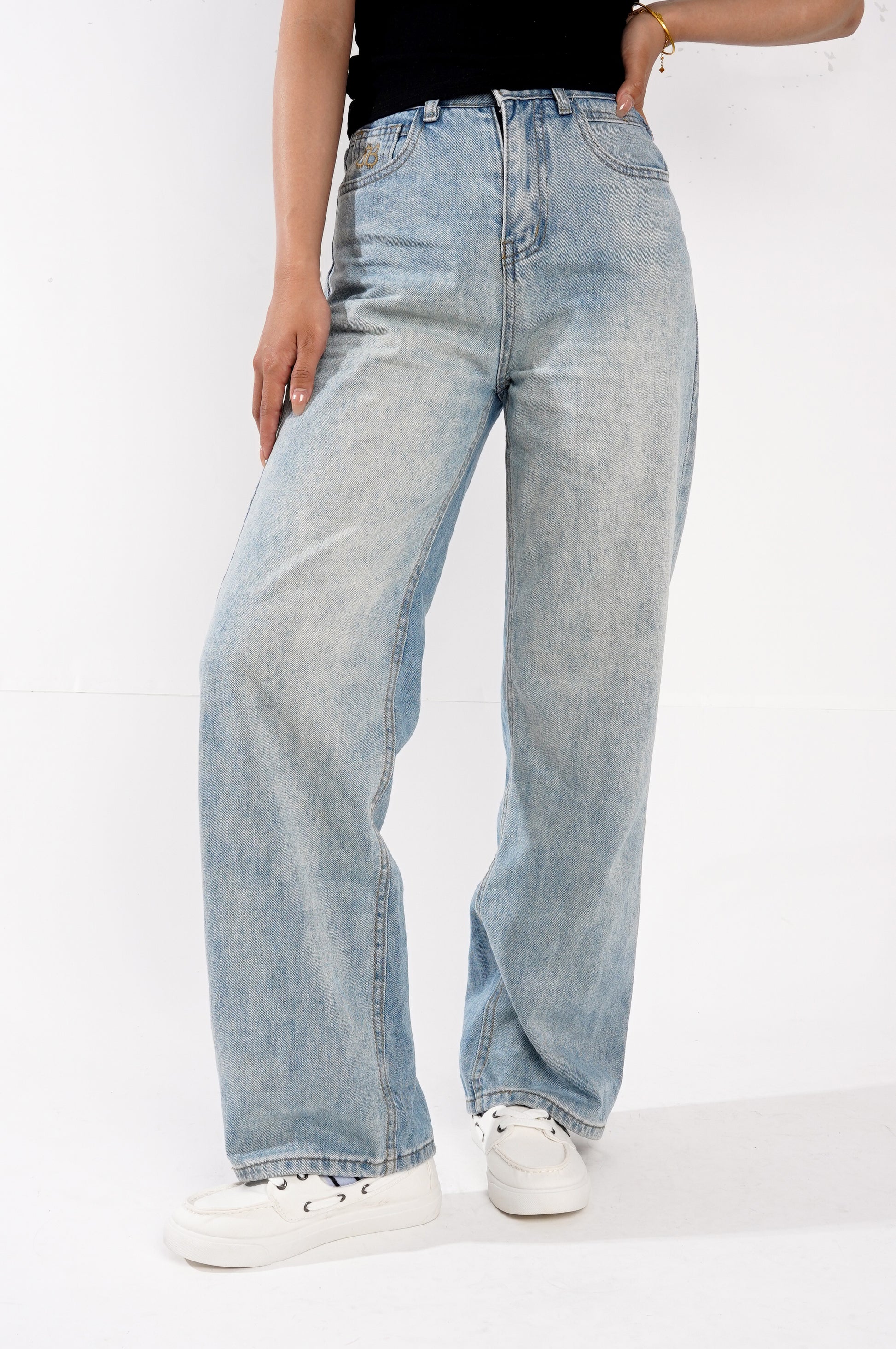 Women's white boat shoes with Project Cloud light blue jeans. Perfect for comfort and style.